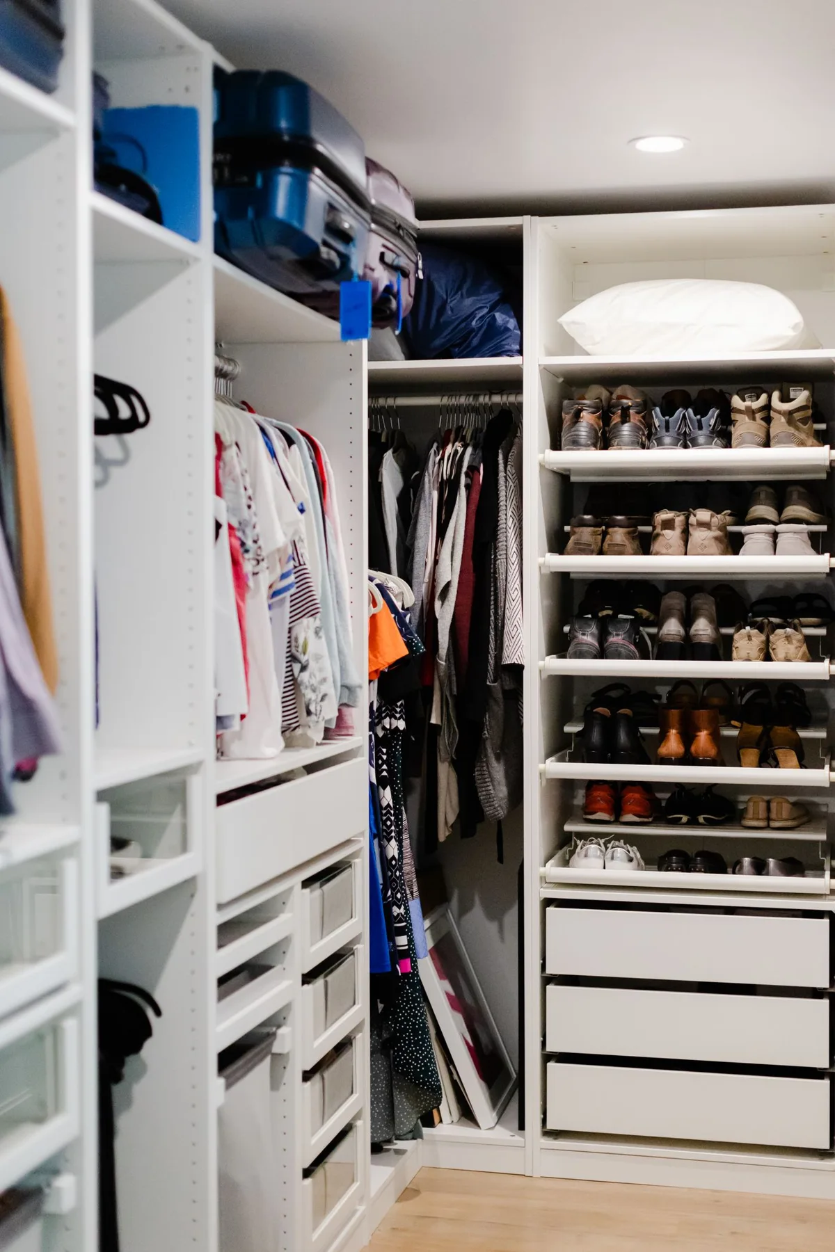 Clothes and shoes organized on white closet shelves