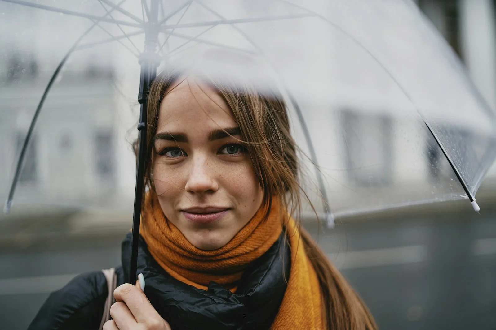 Woman standing outdoors under an umbrella