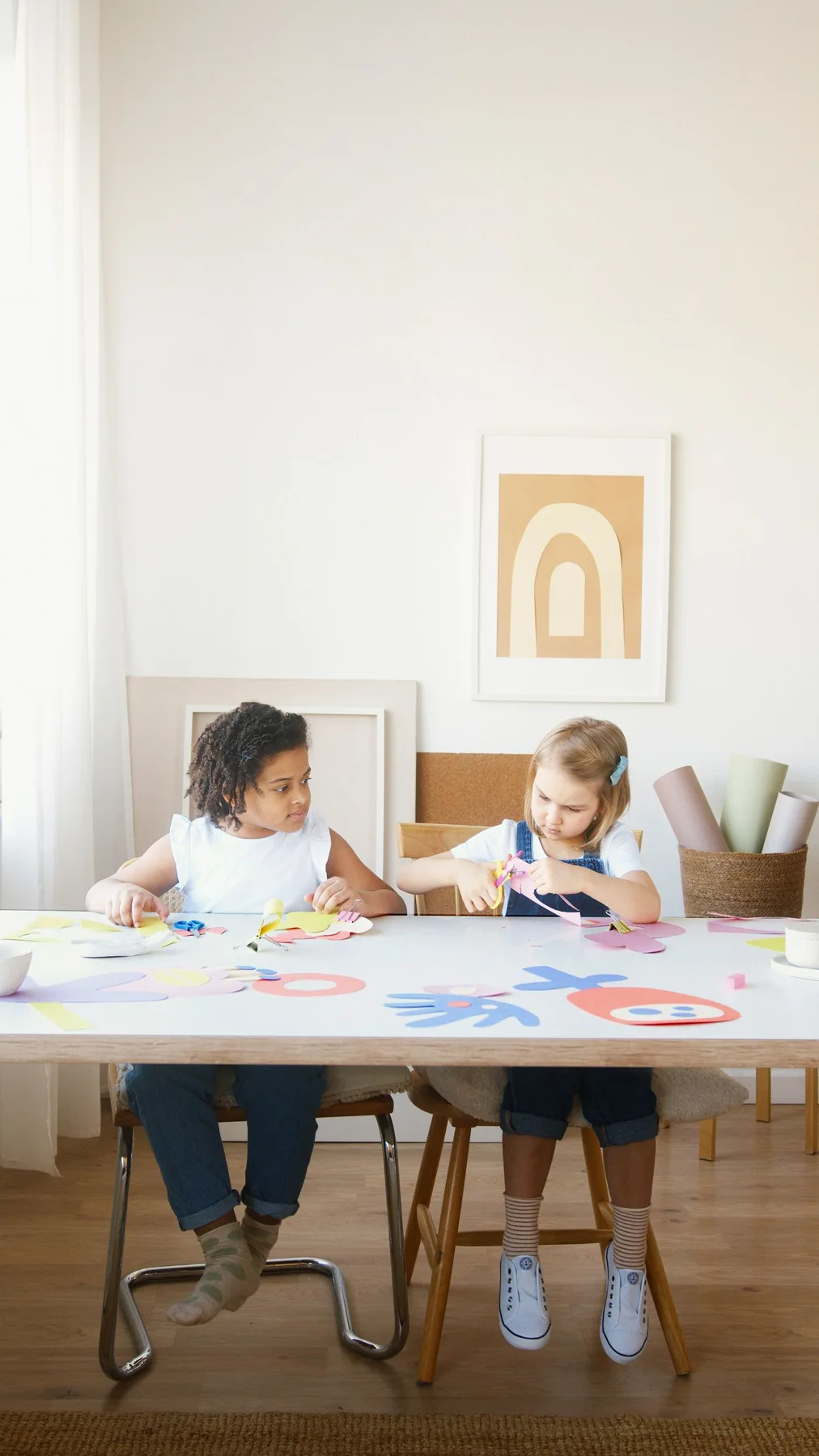 Two children making crafts with paper and art supplies