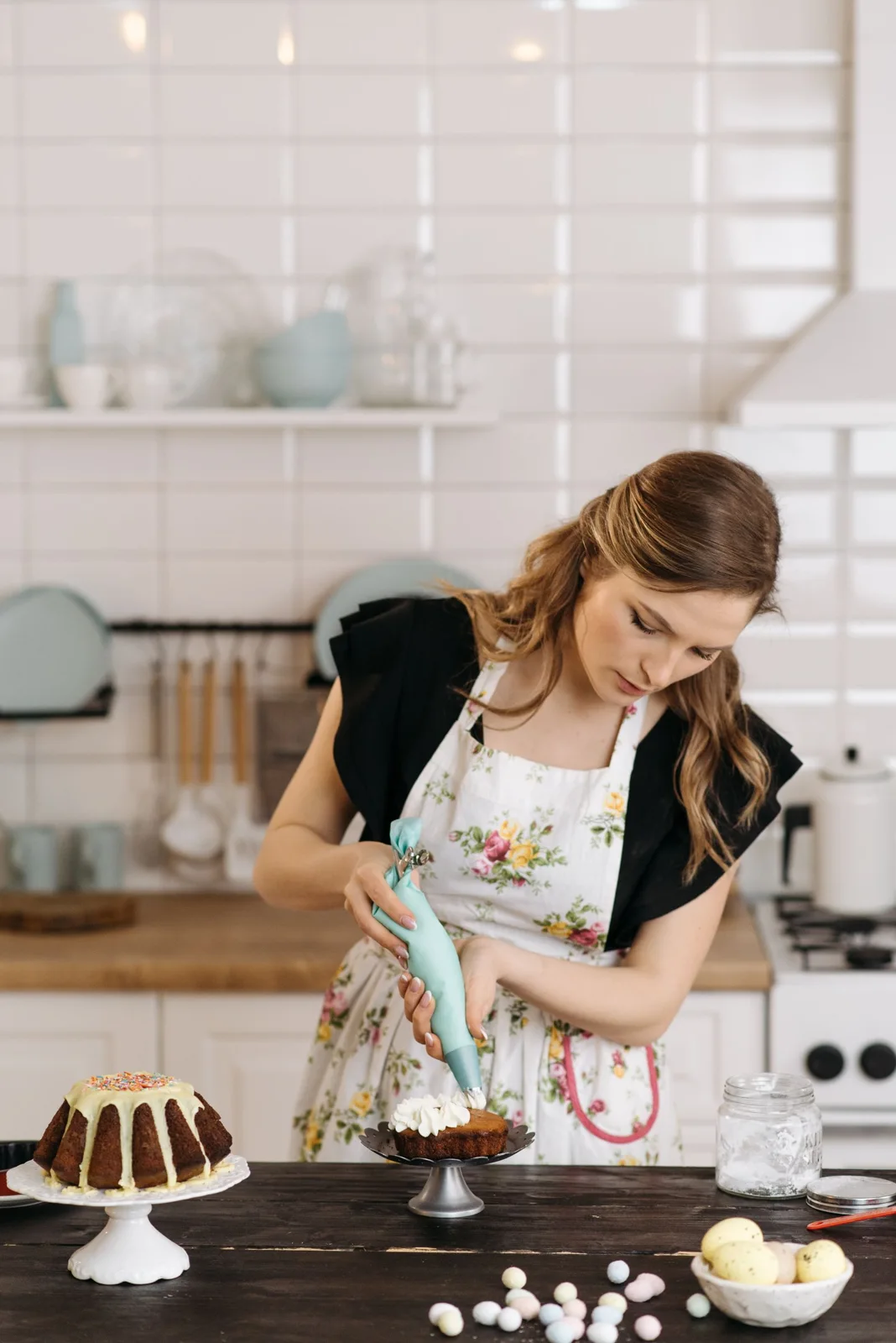 Woman working with a piping bag at a kitchen counter