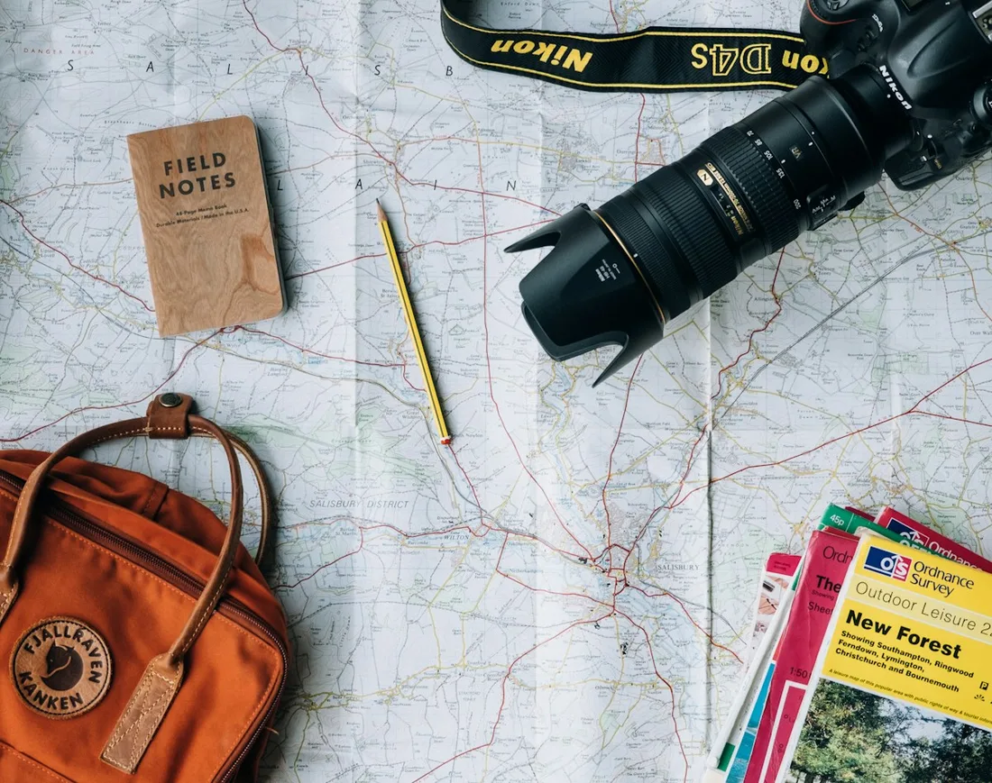 Camera, maps and travel guides arranged on a table